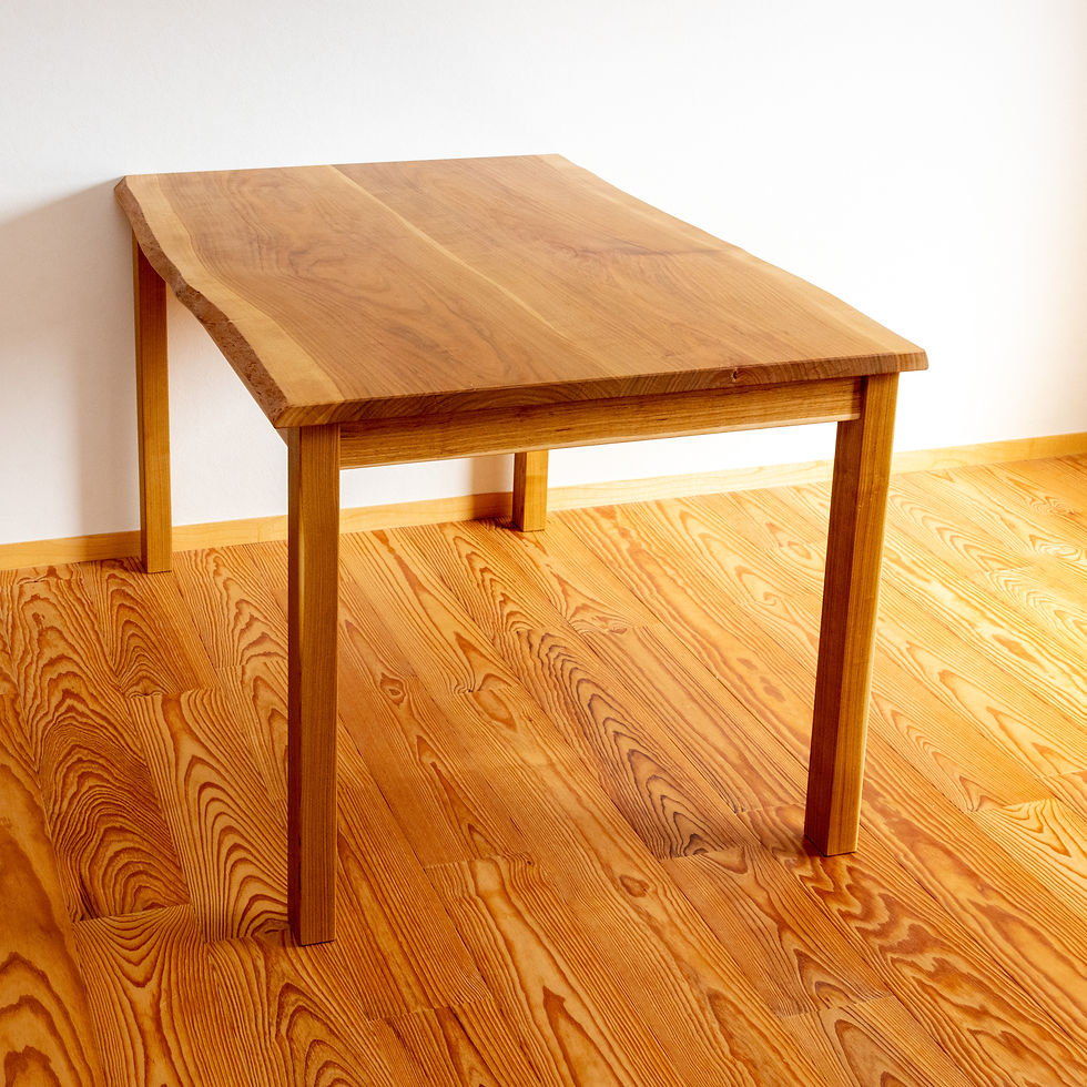 ナチュラルな木目のテーブルが木製フローリングの部屋に置かれている。明るい自然光が温かみを感じさせる。