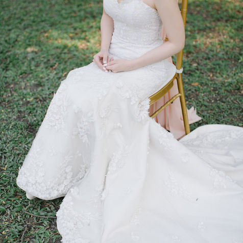 Detailed shot of thick white wisteria flowers and greenery cascading down an elegant curved white architectural backdrop.