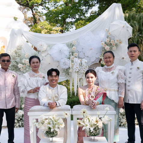 Traditional Thai water pouring ceremony setup with the couple seated at white decorative tables.