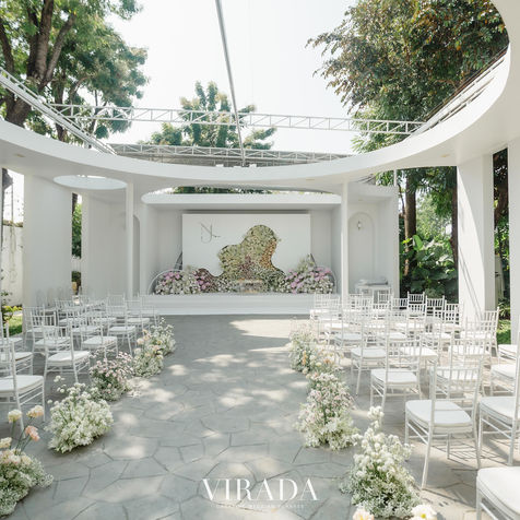 A wide view of an outdoor ceremony site with a modern white pavilion.