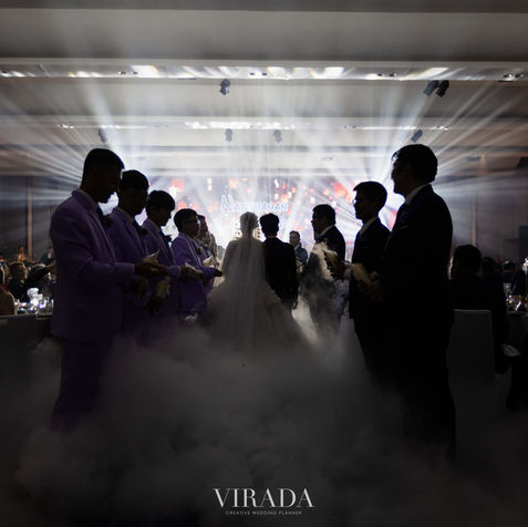 Silhouette of the bride and groom dancing on a smoke-filled floor with dry ice low fog effect.