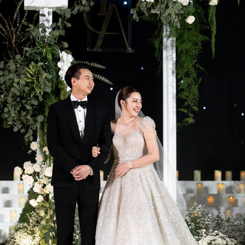 A creative wedding seating plan for 'Milk & Pui' tied with a large bunch of white balloons.