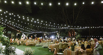 Garden wedding decorated with string lights creating a warm and romantic atmosphere