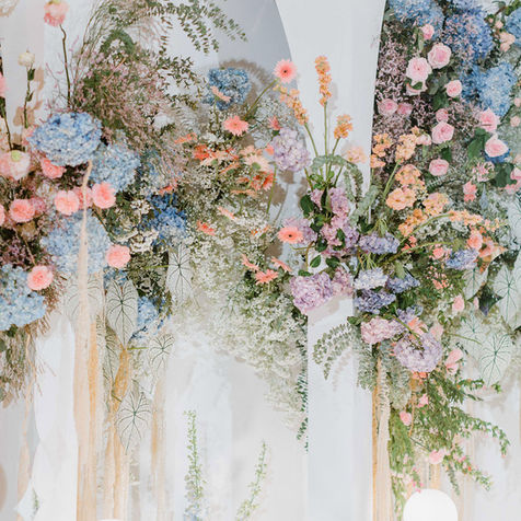Close-up of a vibrant floral installation featuring pink, blue, and white roses.