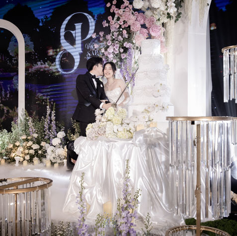 An elegant main sweetheart dining table draped in silver tinsel and heavily decorated with fresh white flowers.