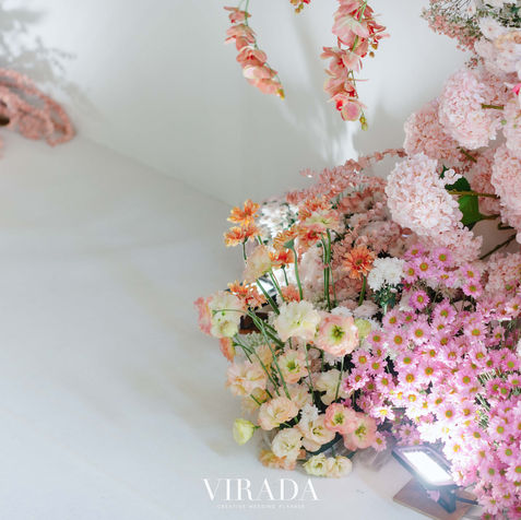 Soft-focus shot of pastel pink and yellow flowers against a clean white background.