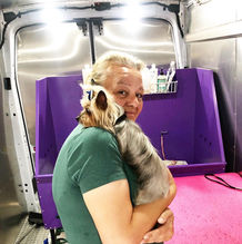 A Lilly's mobile dog grooming team poses with a dog