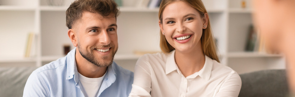Couples therapy. Grateful husband and wife shaking hands with their therapist at psycholog