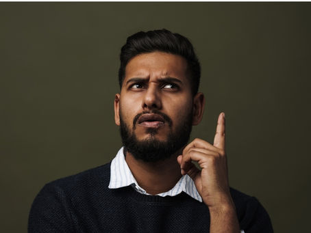 A middled aged Indian man looking confused about his loan situation.