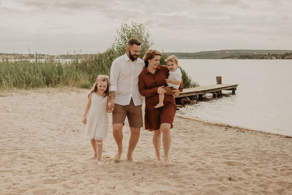 Eine Familie geht am Strand spazieren.