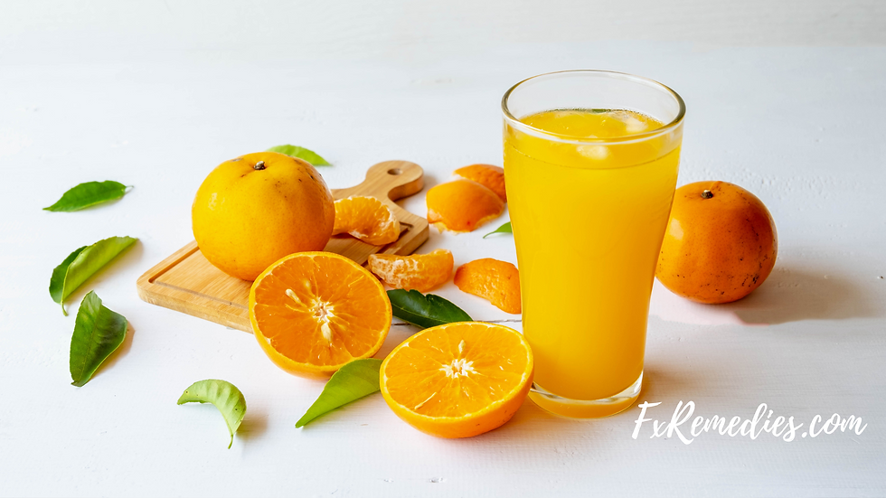 Glass of orange juice with whole and sliced oranges on a wooden board. Green leaves scattered on white surface. Text: FxRemedies.com.