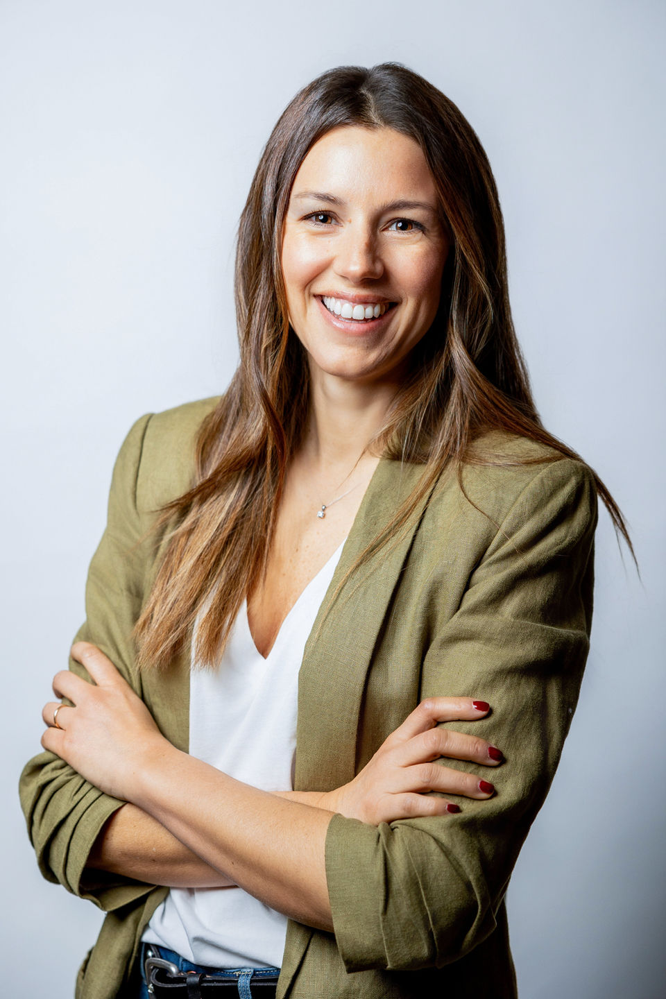 Headshot of a confident woman, exuding professionalism and warmth, with natural lighting highlighting her features