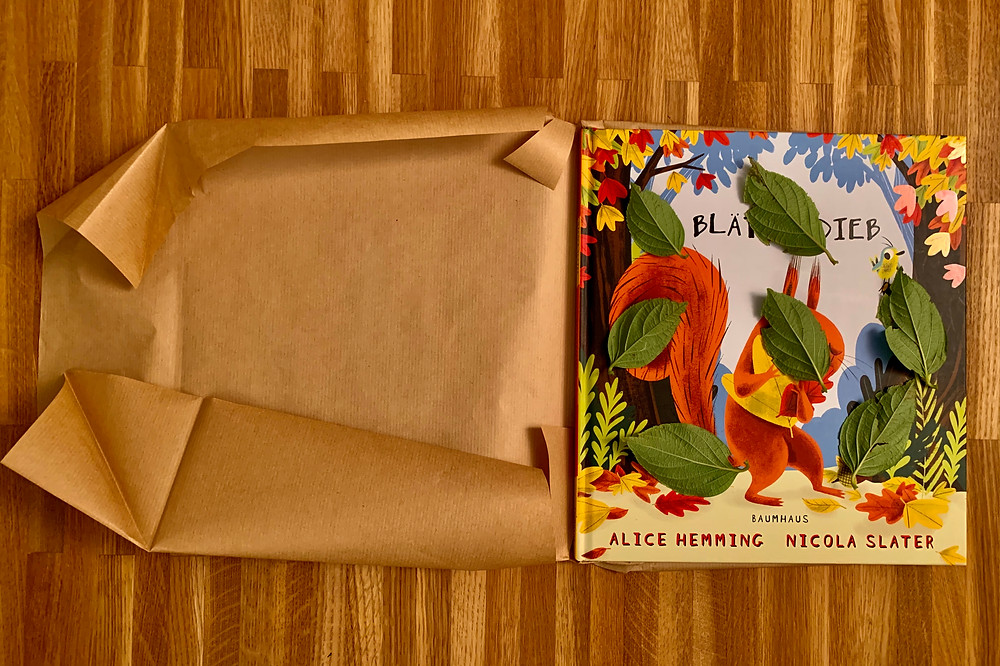 Blätter mit der linken Seite nach oben auf das Cover und die Rückseite legen. Das Buch mit Packpapier einpacken.