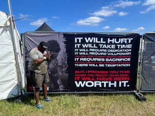A man praying in front of a sign