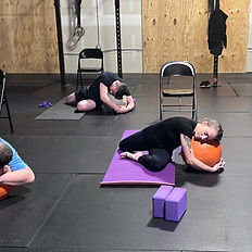 Students practicing a restorative variation of king pigeon pose.