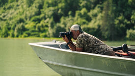 Rjavi medved ob reki na Aljaski v času poletnega lova na losose. Fotografirano s FotoPOTEP-a v narodnem parku Katmai.