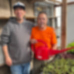 Men in recovery watering seedlings
