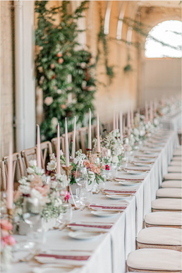 An abundance of garden roses, sweet peas, stocks and delphiniums on a stunning wedding breakfast table at Grittleton House, Sussex.