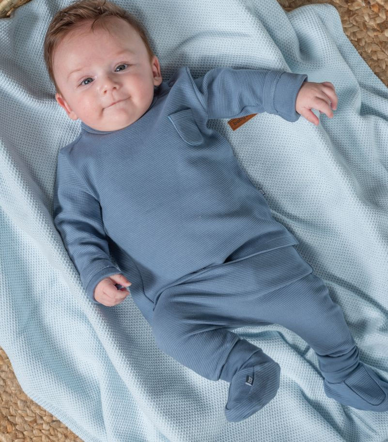 Baby trägt Pure Booties Blau in Babyschale