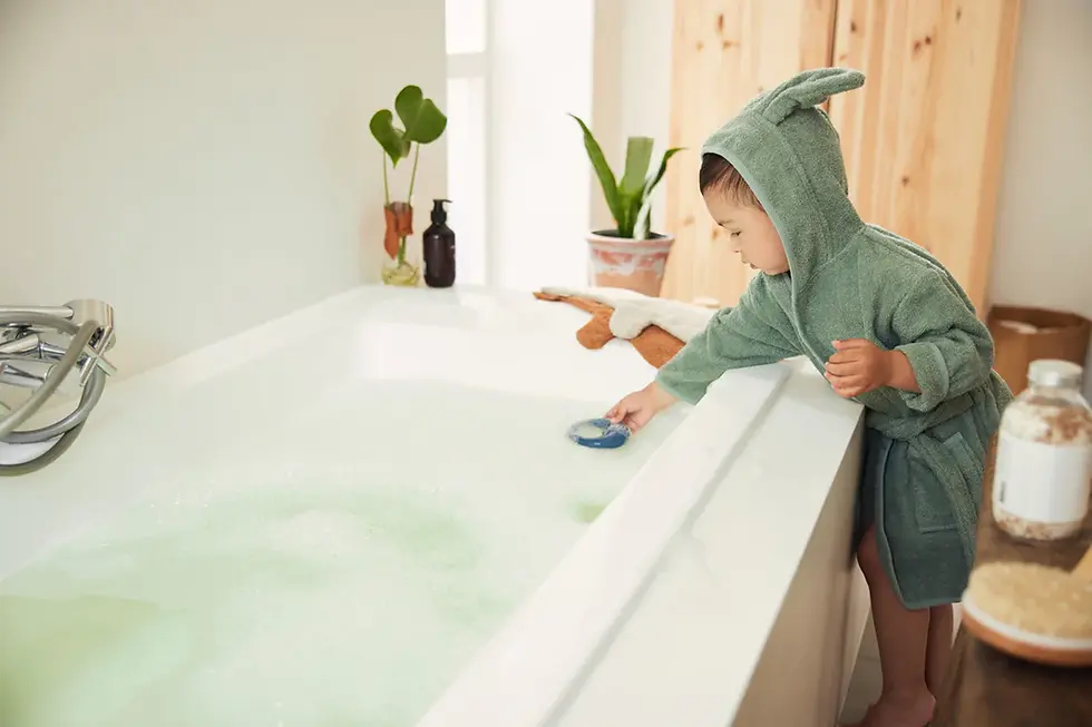 Kind trägt Bademantel 3-4 Jahre Ash Green – nach dem Baden am Waschbecken