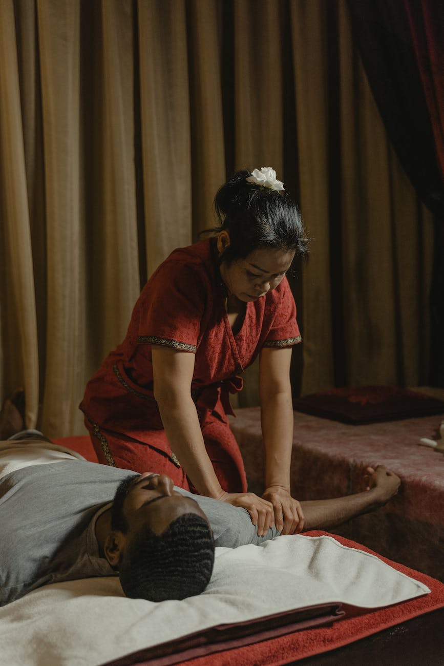 woman in red shirt massaging man s hand