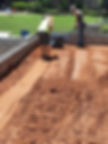 Workers excavating and compacting dirt for a foundation.