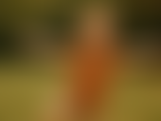 heart-filled photo of a child giggling, eyes scrunched in joy, standing in tree pose with arms wide open like branches. Their shirt is slightly crooked, their hair messy from play and they are completely radiant.