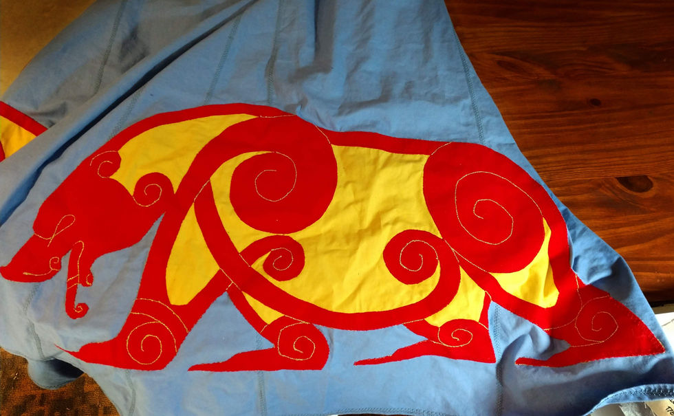 Red and yellow bear design appliqued on a blue fabric background