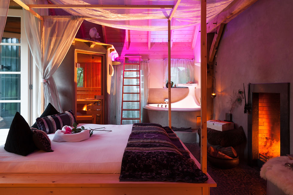 Sfeervol wellnessinterieur met bed, sauna en zachte roze verlichting