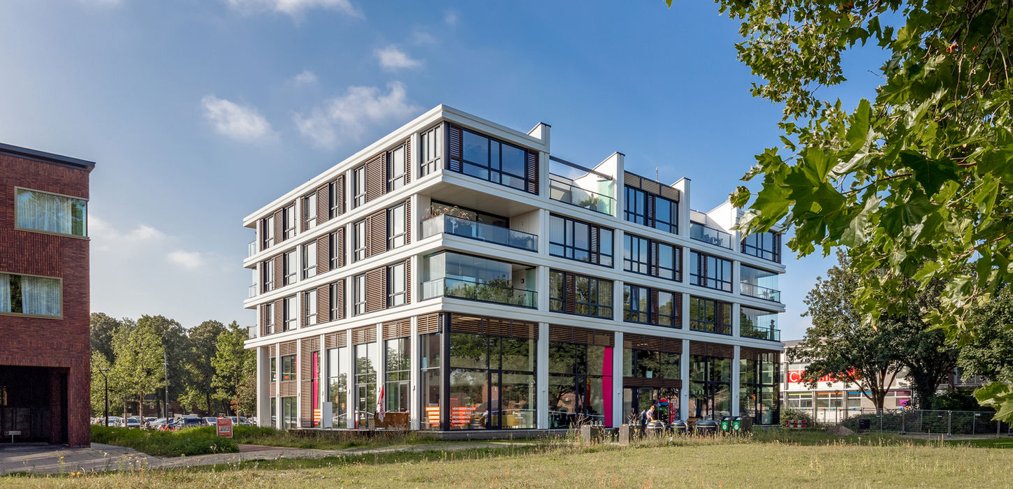 Modern wit gebouw met grote ramen en balkons