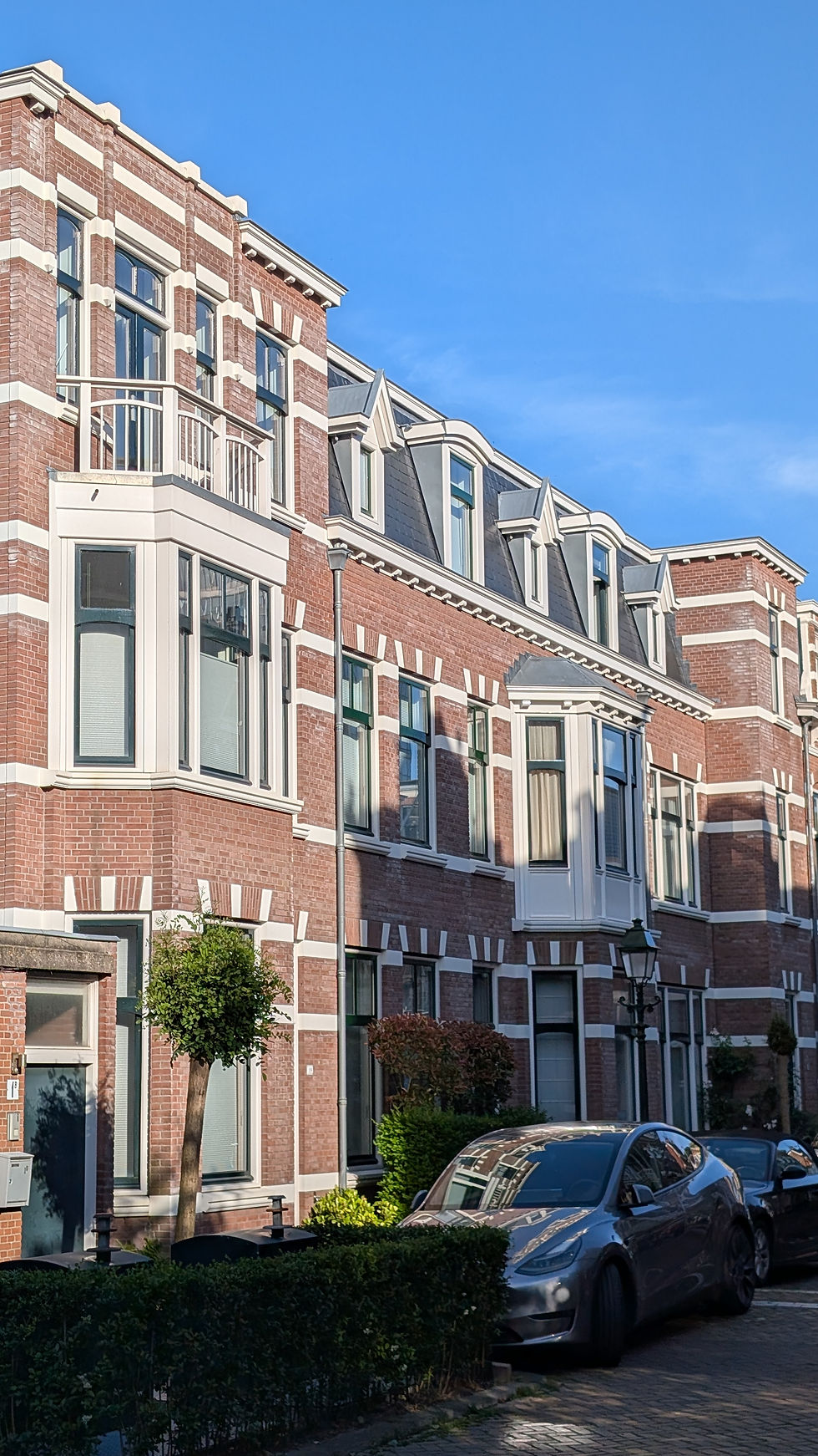 Klassieke bakstenen herenhuizen in een Nederlandse straat