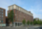 Modern bakstenen appartementsgebouw aan een stadsstraat.