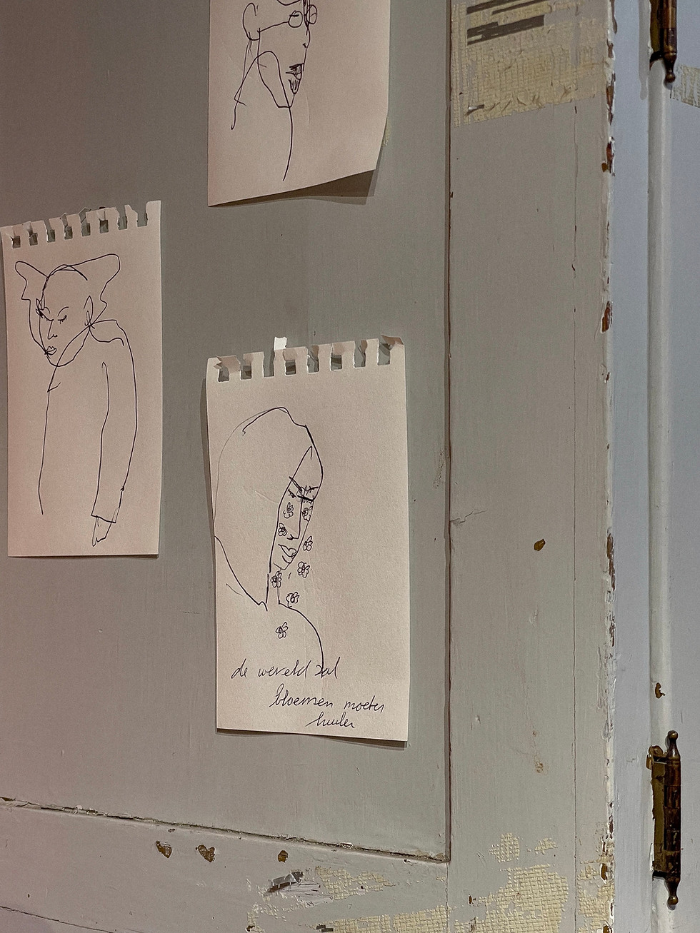 Drie handgetekende schetsen op papier: een figuur, een profiel en een gezicht.