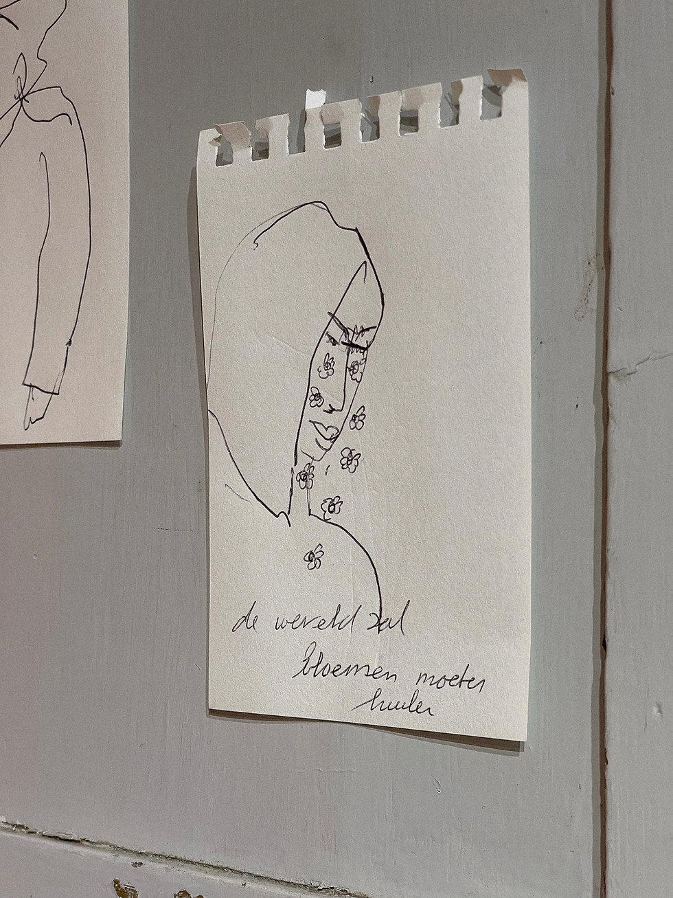 Lijnschets van een figuur met capuchon en bloempjes op papier
