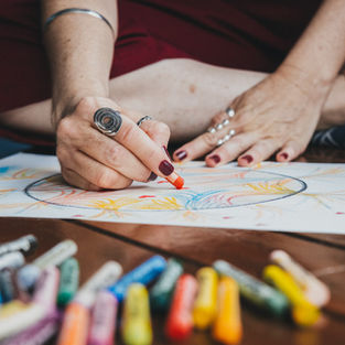 mão de uma mulher desenhando uma mandala