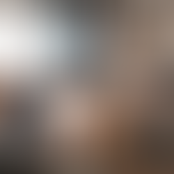 People gathered around a wooden table in a cozy, modern office. They're engaged in a meeting, with papers and bottles visible. Mood is collaborative.