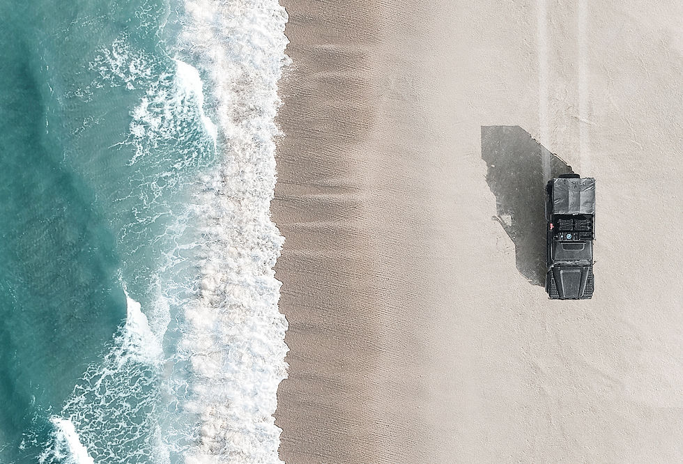 Land Rover Defender cruising next to the sea