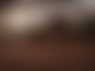 Overland camp at sunset with a Land Rover and rooftop tent set up under trees, a campfire glowing in the sand, and a person relaxing at a small table, capturing the quiet bush camping lifestyle and slow travel spirit of Gravel & Salt.