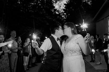 A wedding couple kissing holding sparklers.