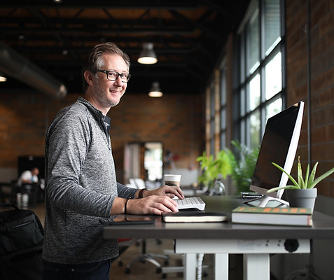 Un manager expérimenté, à son bureau, souriant