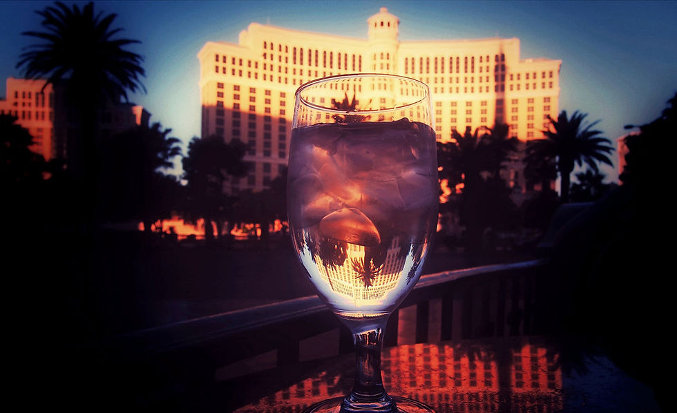 A group of tourists taking photos with beautiful cocktails for social media, unaware that the drinks are weak and overprized—a common Strip scam.