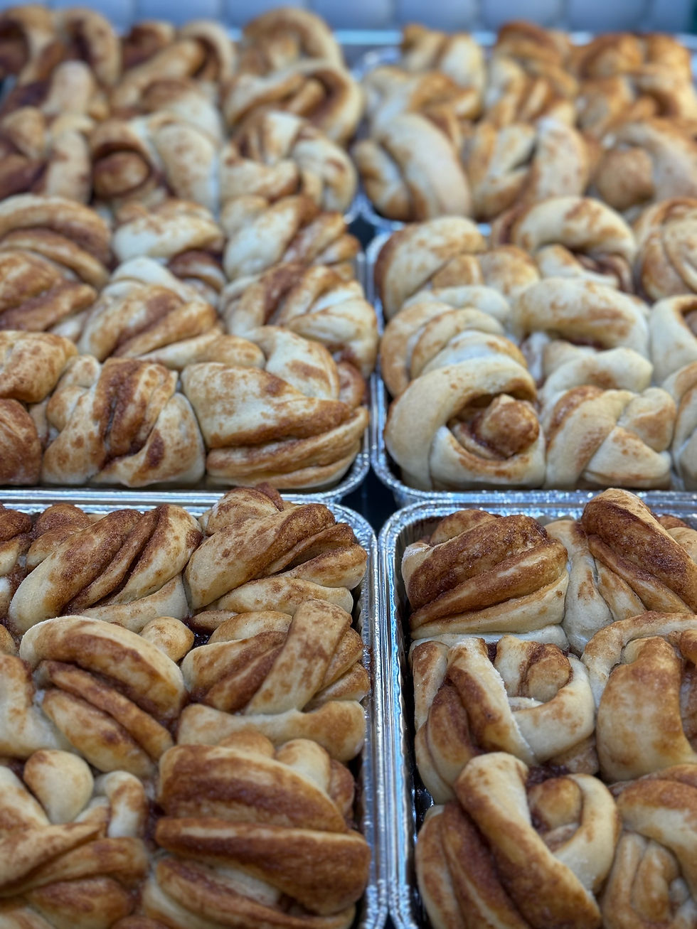 Thumbnail: Overhead view of fresh-baked Bread Barn cinnamon rolls in metal pans