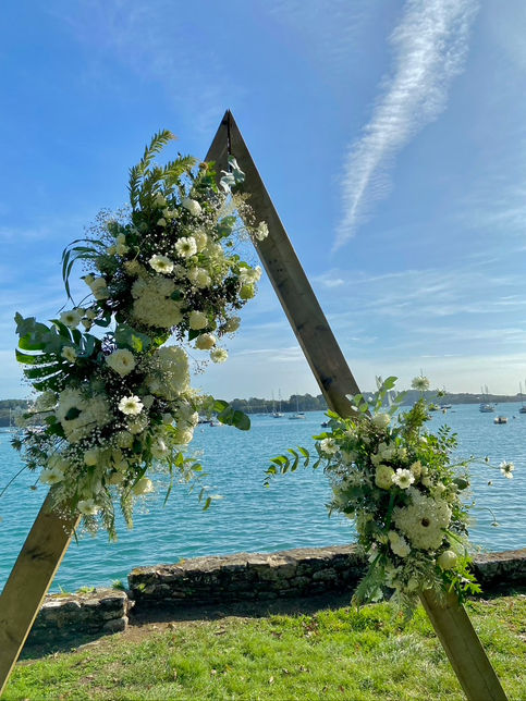 Arche en A fleurie dans les tons blancs et verts pour un mariage breton en bord de mer à DINARD