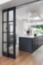 bespoke sliding door at the open plan kitchen in Maida Vale, West London, designed by Catherine Wilman