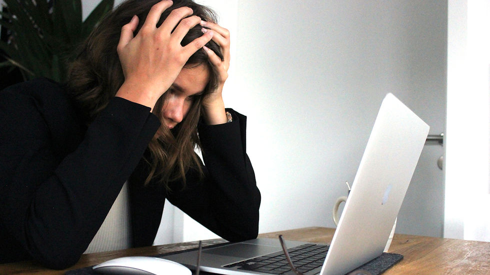 Stressed businesswoman holding her head while working on laptop — symbolizing website compliance issues with EU and Italian r