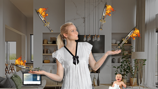 Woman in a white dress juggles flaming swords in a modern living room. A baby smiles nearby. A laptop on the sofa shows text.