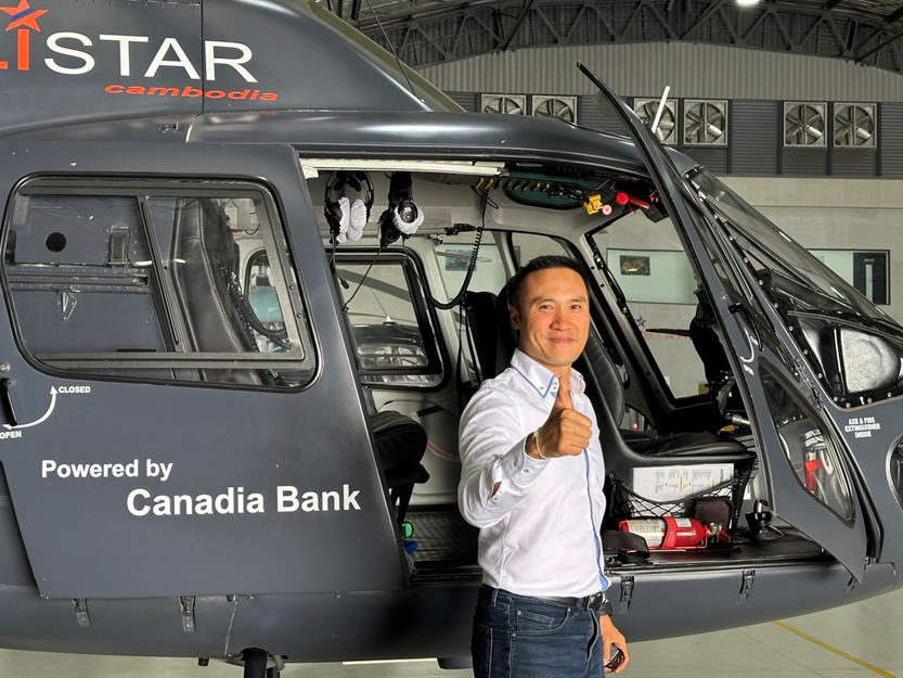 Thierry Tea devant un hélicoptère, dans le hangar