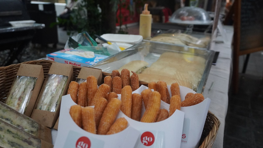 Churros, sandwiches and quiches on the catering stand set up for the morning