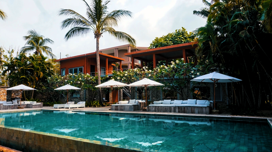 The sunset pool, framed by the terracotta villa and a curtain of frangipani