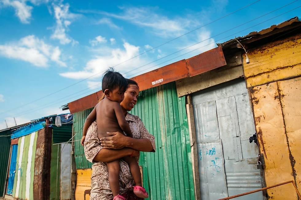 Dans un quartier informel de la capitale cambodgienne, une femme tient son enfant contre elle. Le geste est simple, le regard tendre — elle lui parle à mi-voix, lui seul compte.